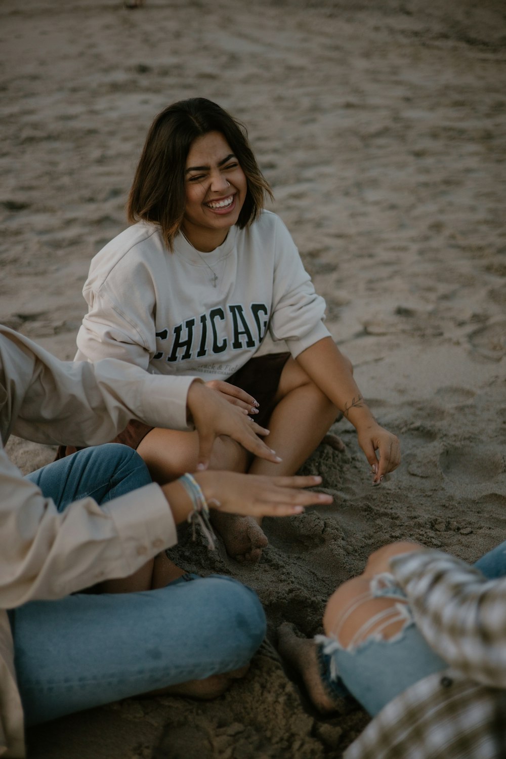 a group of people sitting on top of a sandy beach