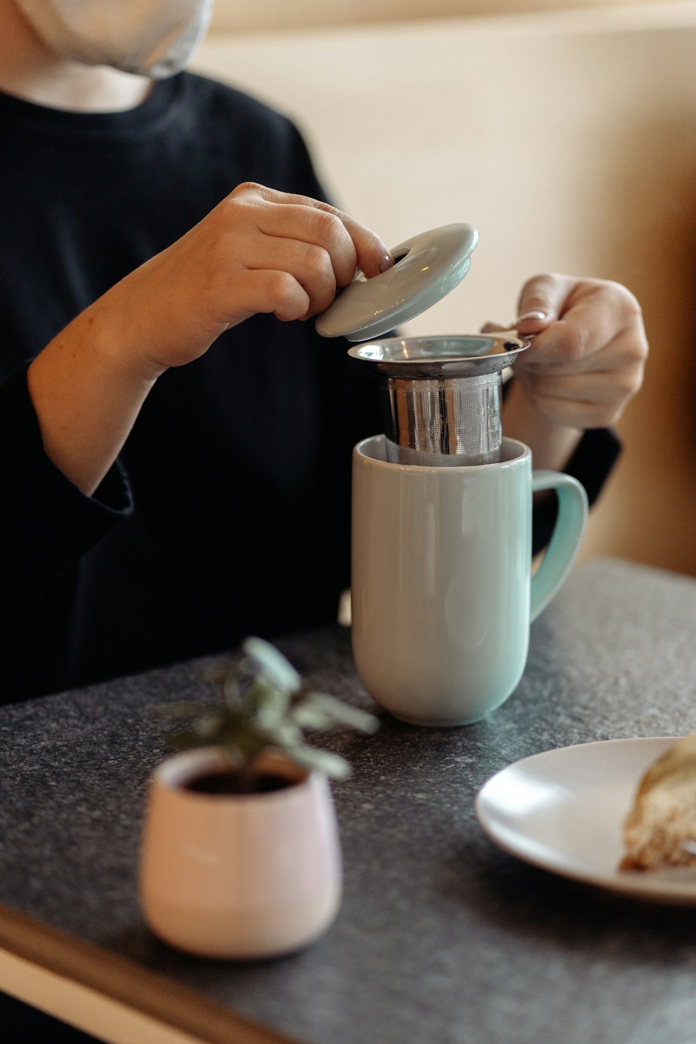 a person sitting at a table with a coffee maker