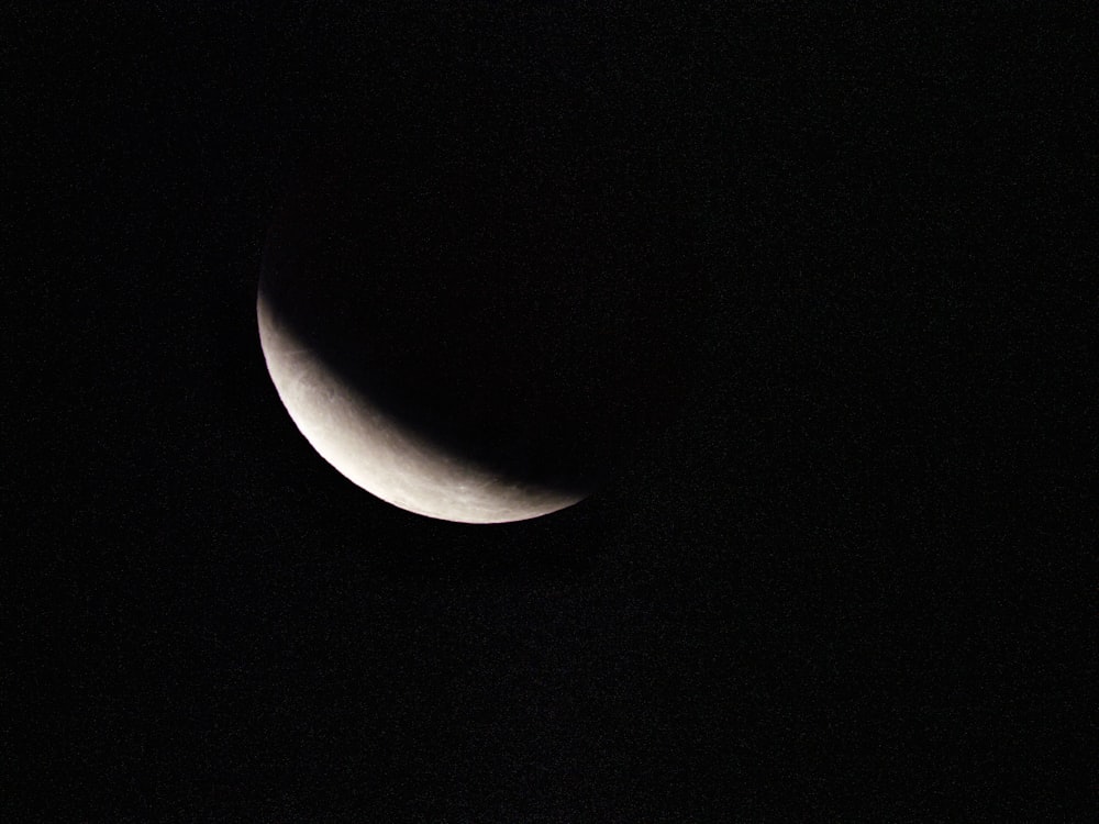 a half moon is seen in the dark sky