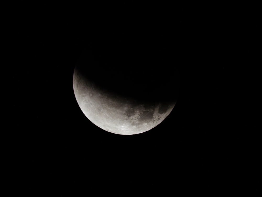 the moon is seen in the dark sky