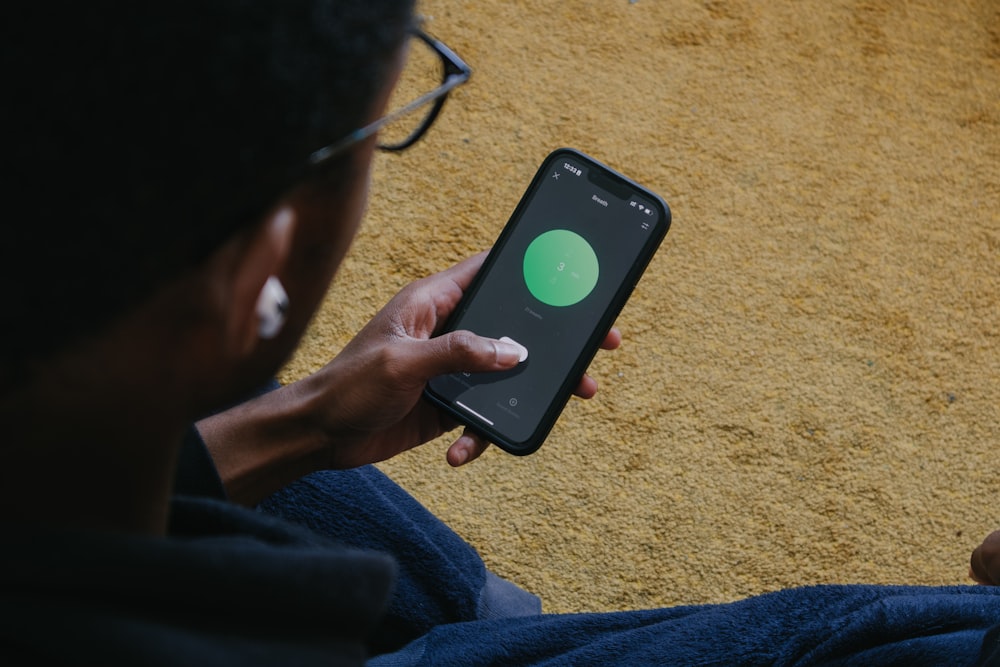 a person sitting on the floor holding a cell phone