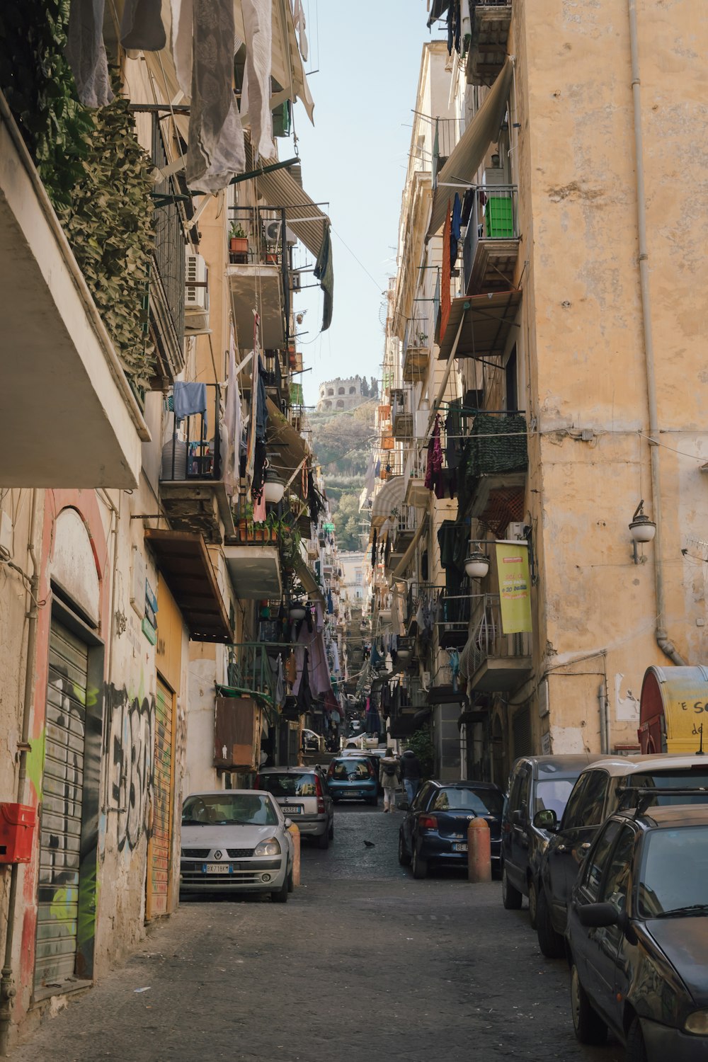 a narrow city street with cars parked on both sides