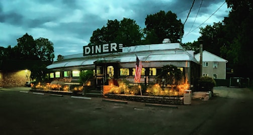A cozy roadside diner bathed in warm sunset light, inviting travelers to pause and connect.