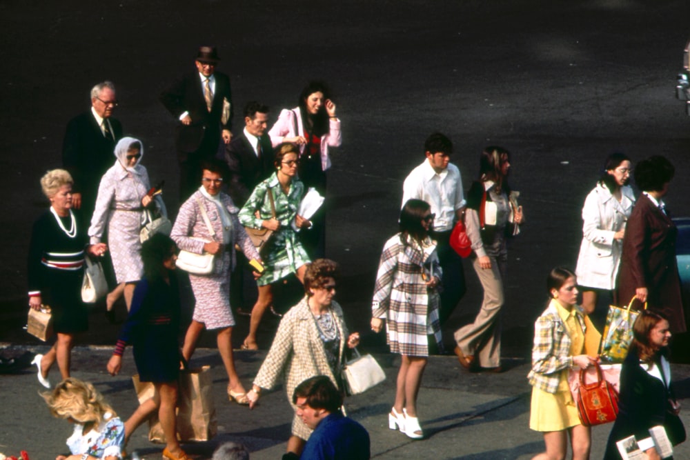 a group of people walking down a street next to each other