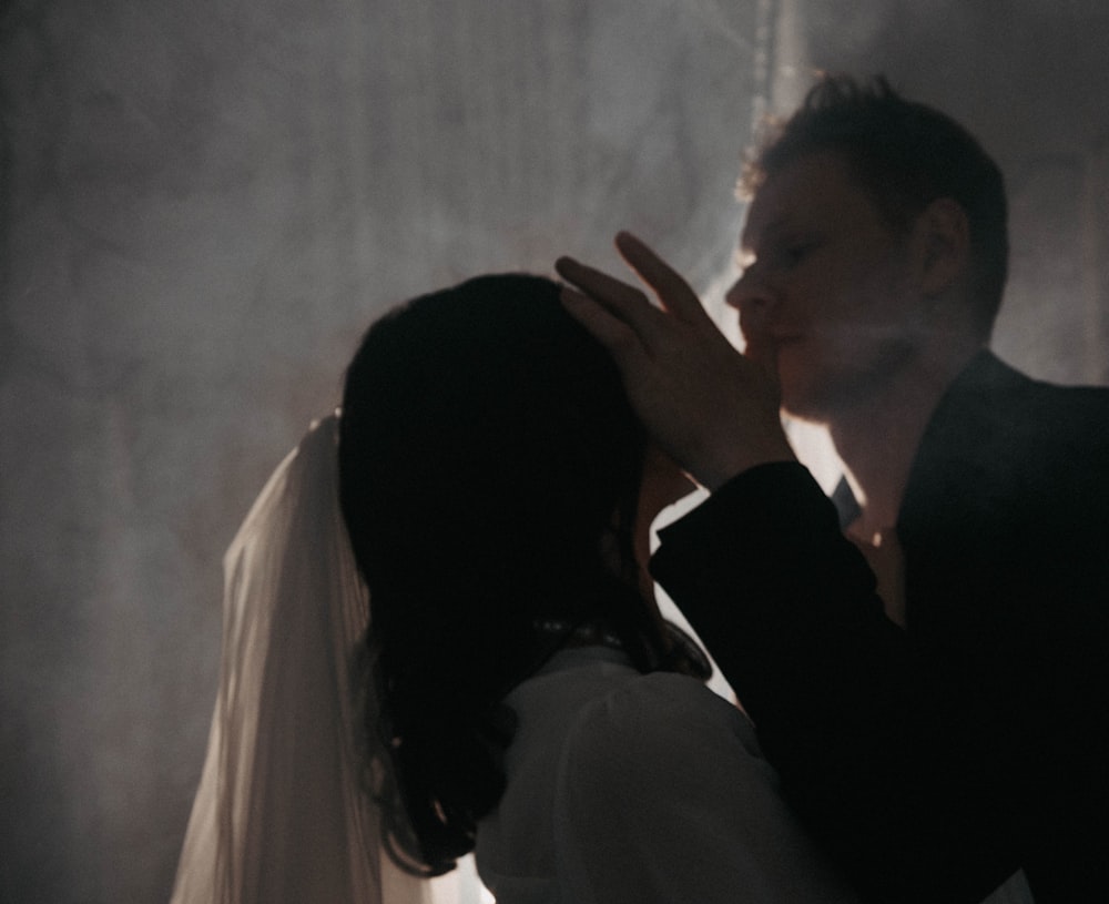 a man and a woman standing in a dark room