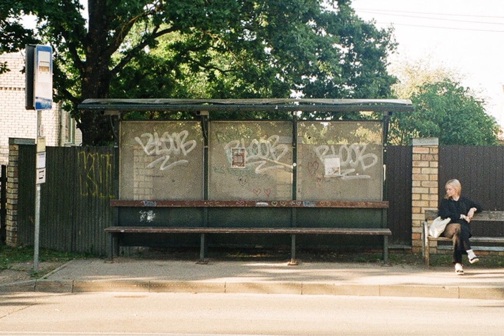 a person sitting on a bench in front of a building