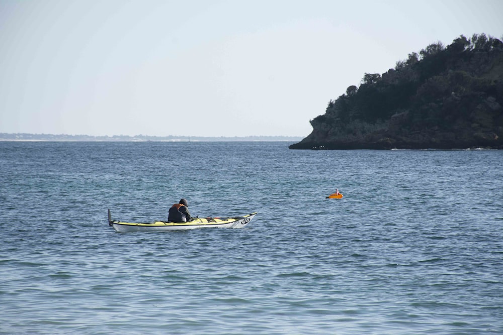 Un uomo in un kayak in mezzo a uno specchio d'acqua