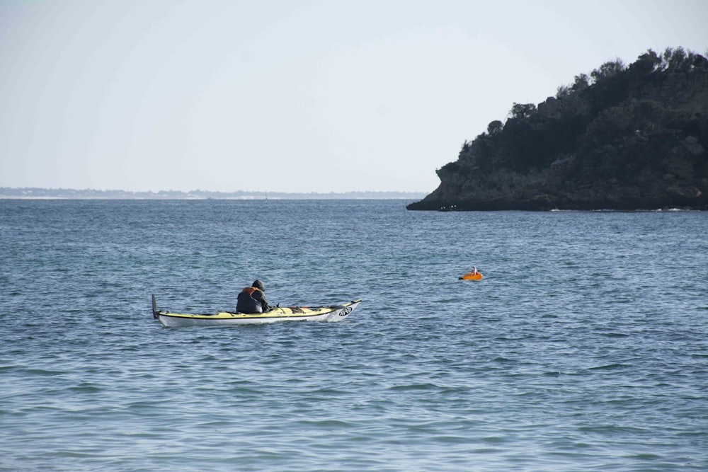 a man in a kayak in the middle of a body of water