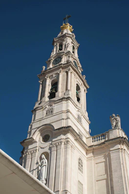 a tall white building with a clock on it's side