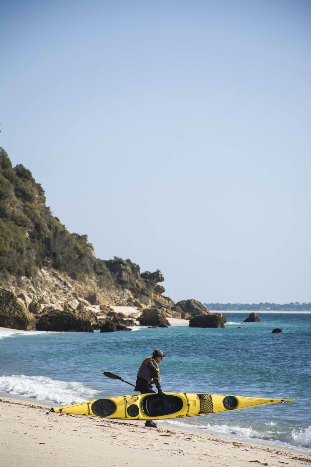 a man sitting in a kayak on the beach