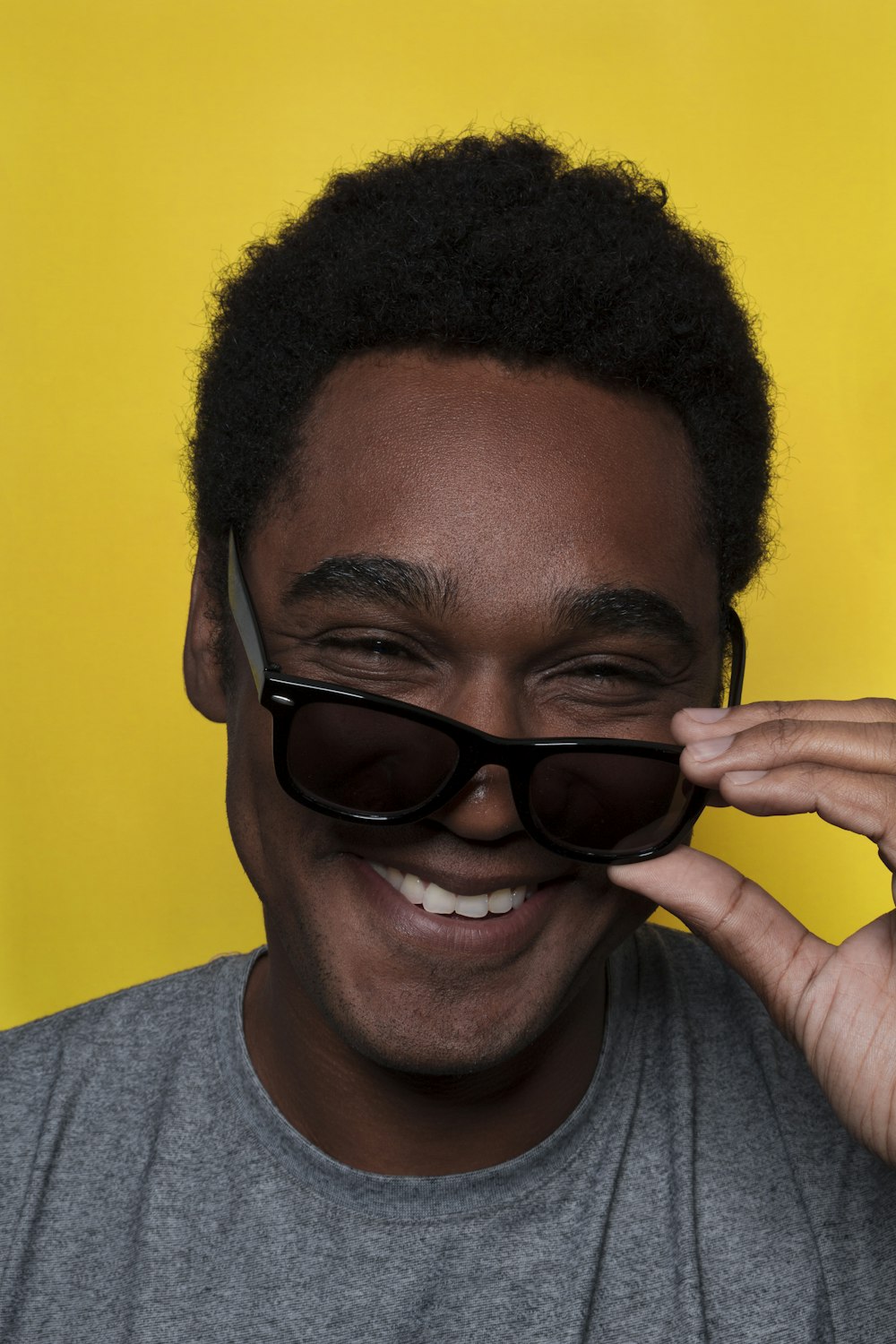 a man with sunglasses on his face smiling