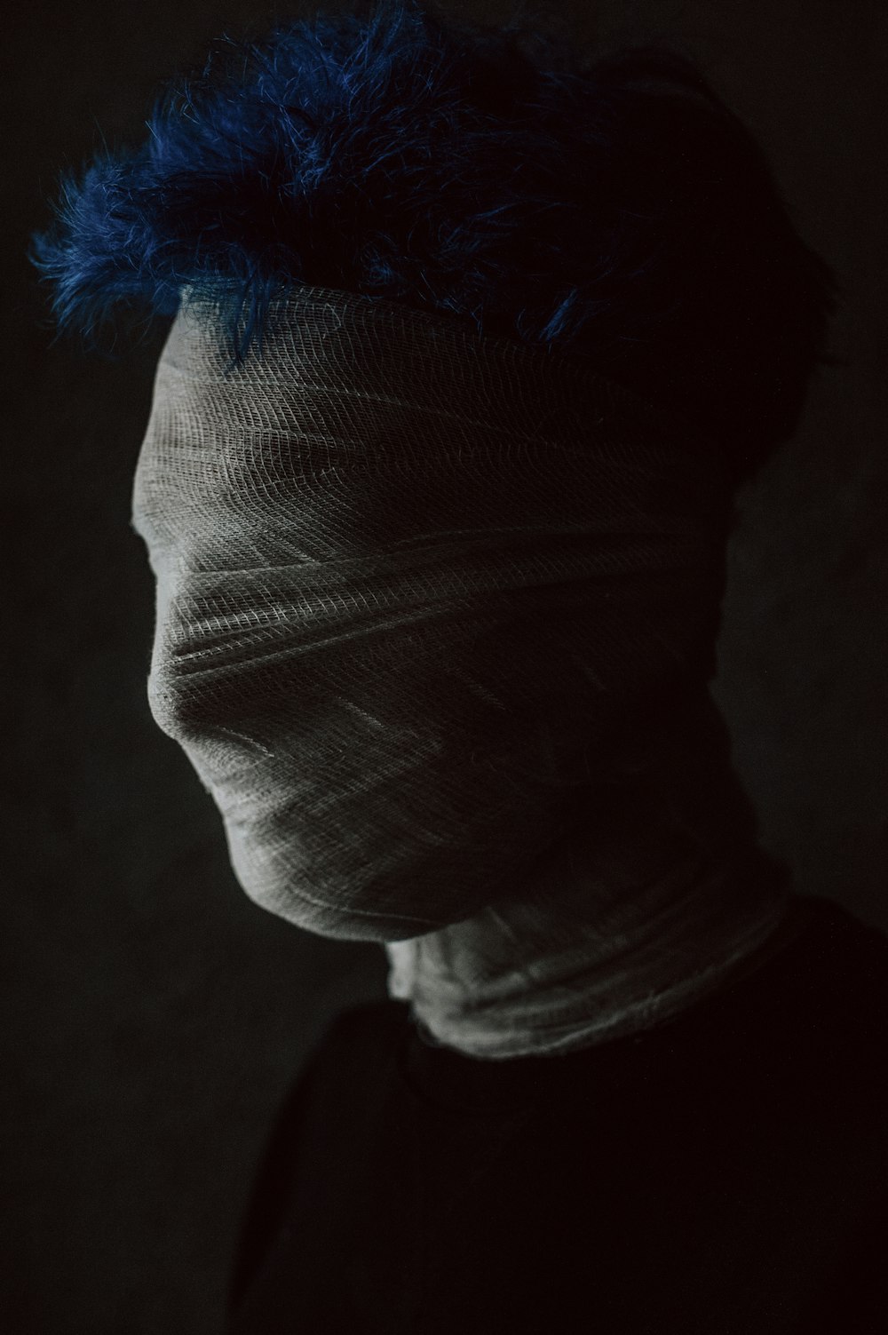 a man with a bandaged head and blue hair