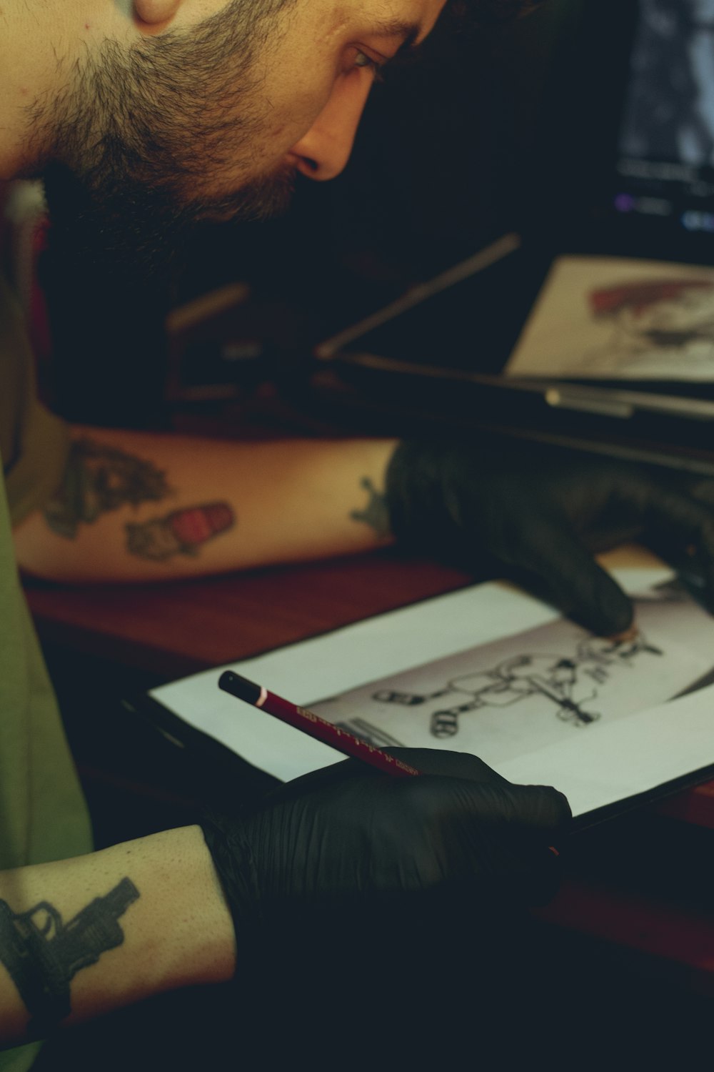 a man with a tattoo on his arm is looking at a drawing
