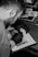 a man with a beard and black gloves working on a piece of paper