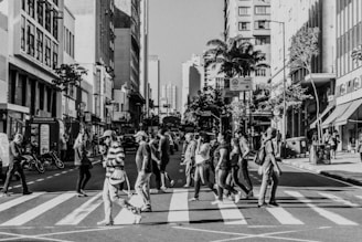 a black and white photo of people crossing the street