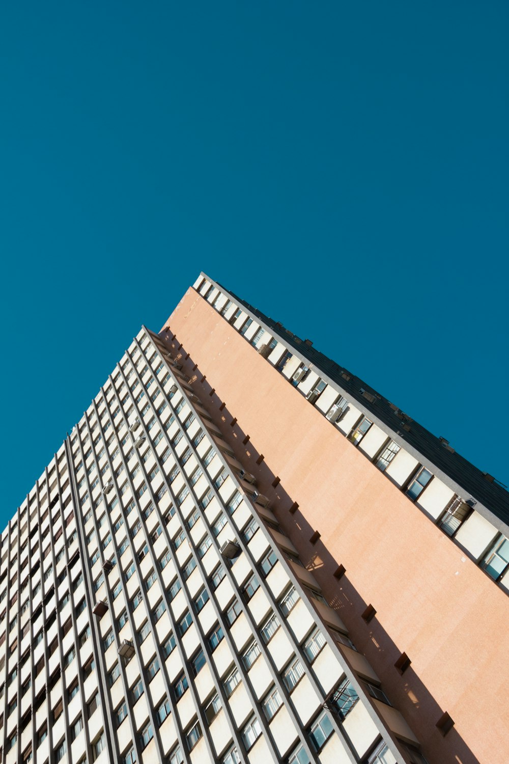 a tall building with lots of windows against a blue sky