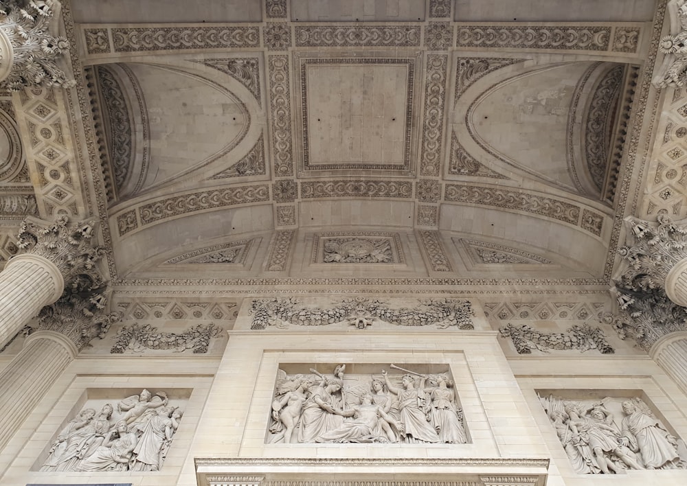 the ceiling of a building with statues on it