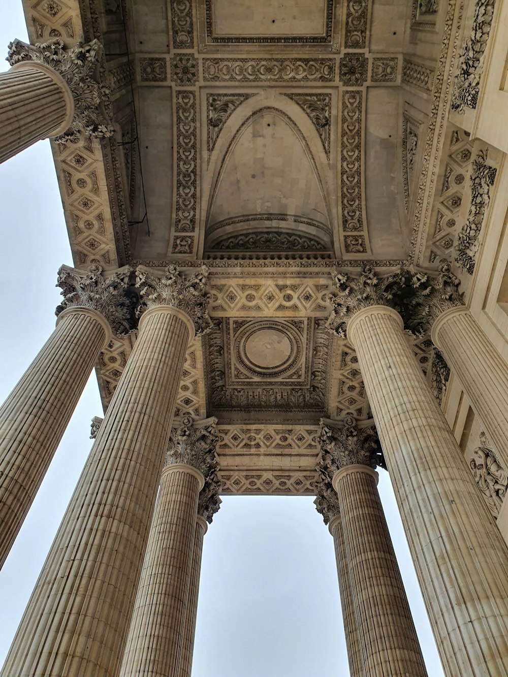 the ceiling of a building with columns and a clock