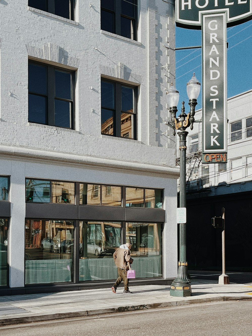 a woman walking down a street past a hotel