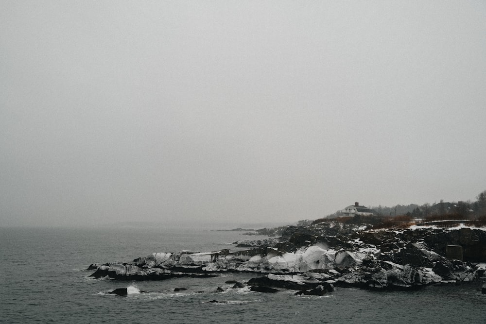 a black and white photo of a lighthouse on a foggy day