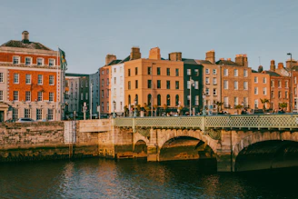 a bridge over a body of water with buildings in the background