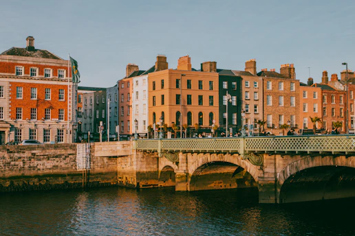a bridge over a body of water with buildings in the background