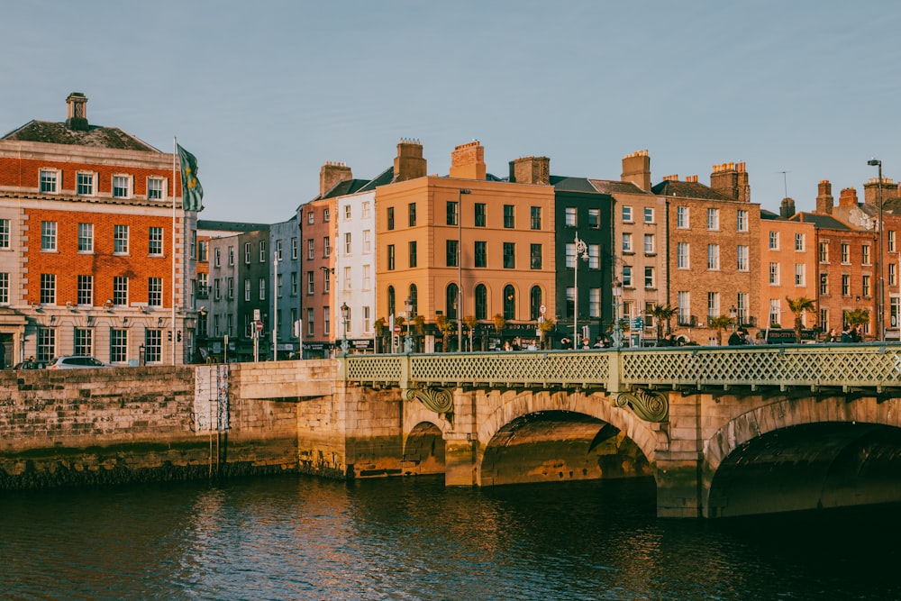 a bridge over a body of water with buildings in the background