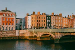 Ponte sobre o rio com prédios de tijolo ao fundo em Dublin