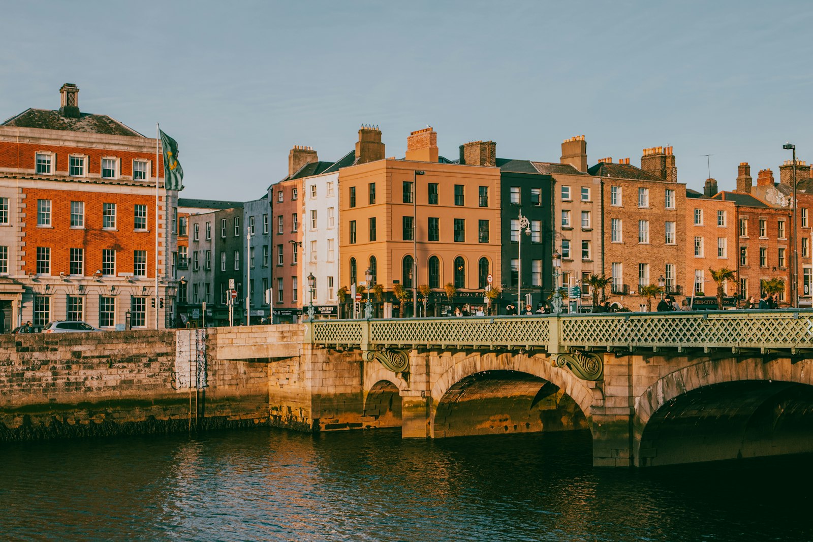 Ha'penny Bridge over the River Liffey in Dublin lined with colorful Georgian buildings at sunset