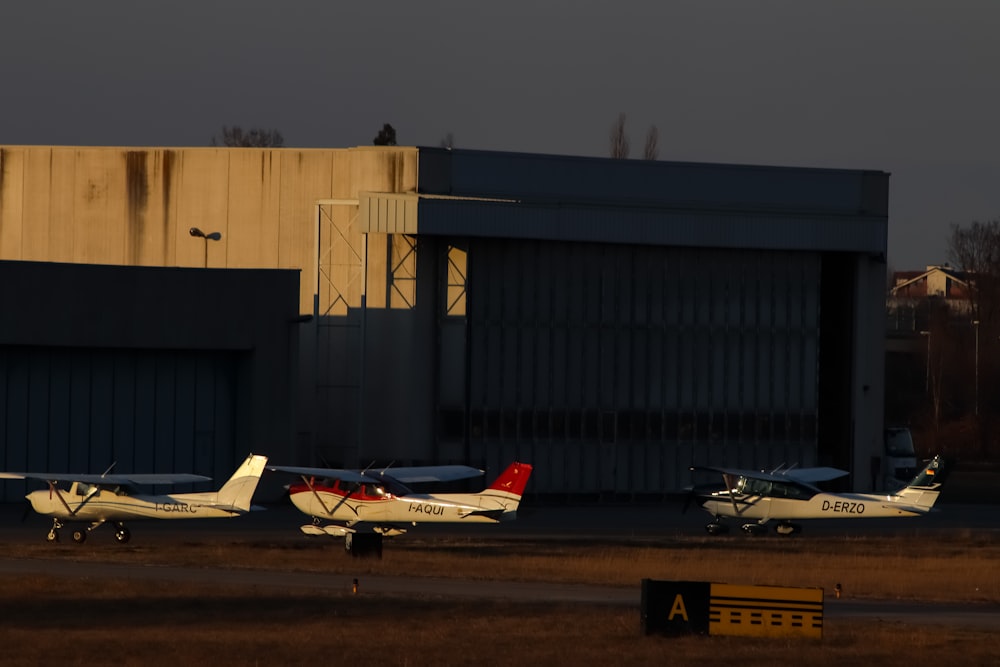 a couple of small planes parked in front of a building