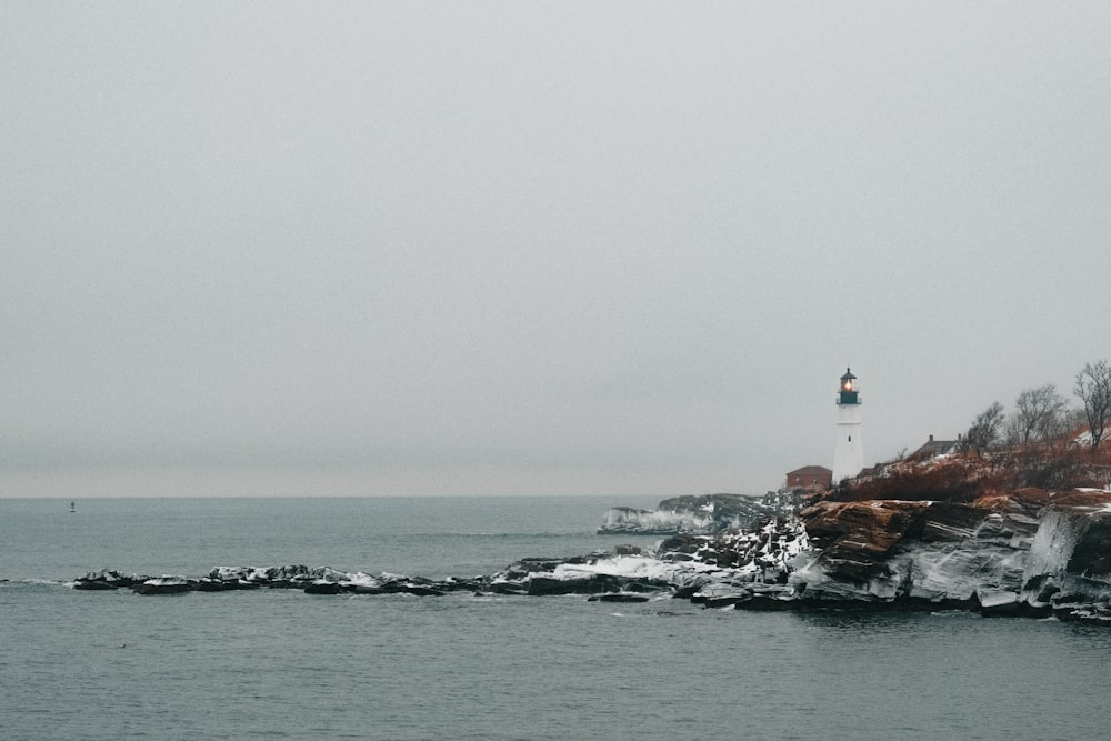 a lighthouse on top of a rocky outcropping in the ocean