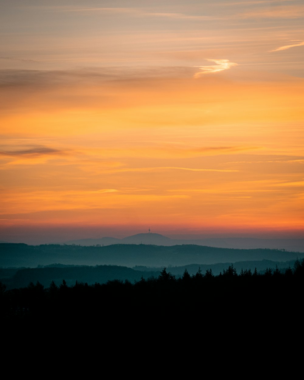 the sun is setting over a mountain range