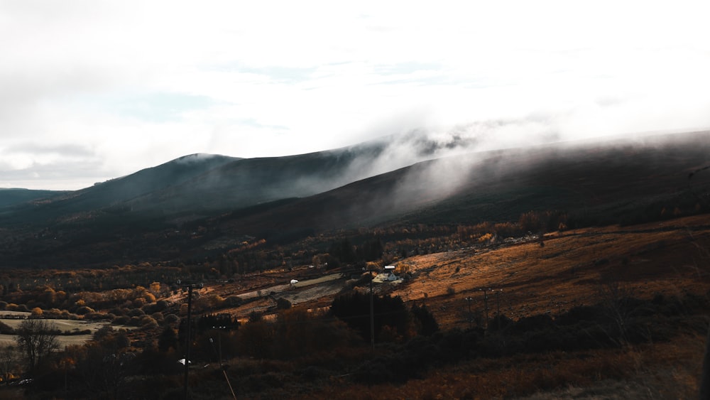 a scenic view of a valley with mountains in the background