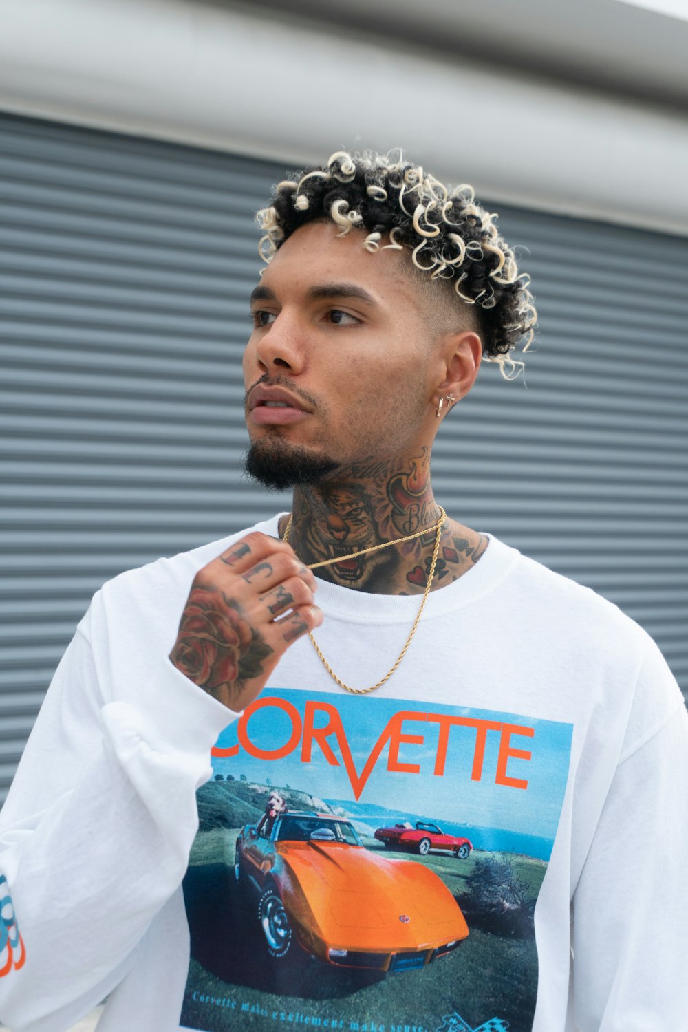 a man with a tattoo standing in front of a garage door