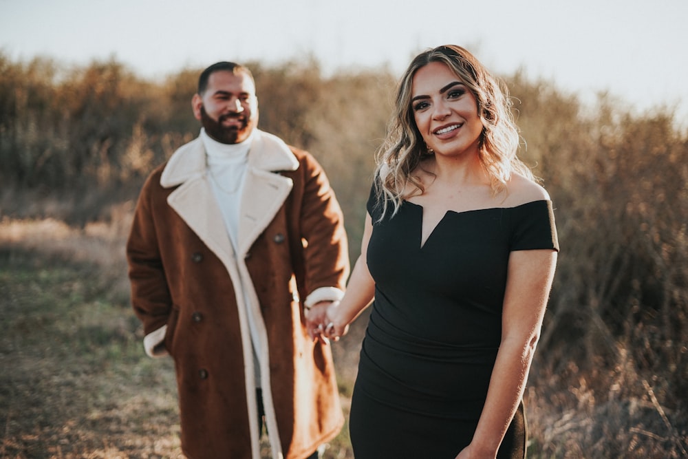 a man and a woman holding hands in a field