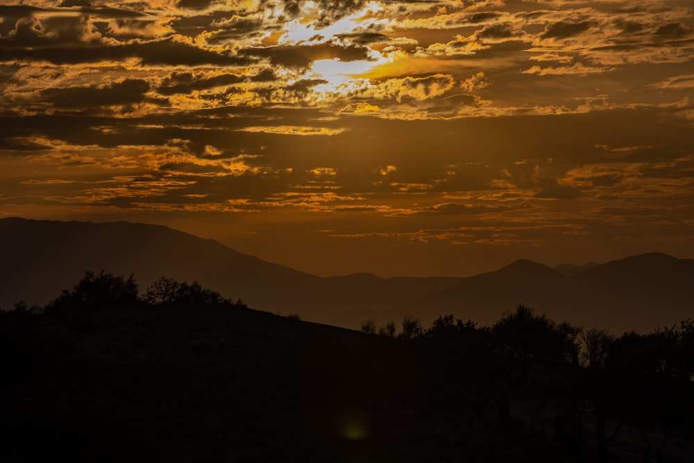 the sun is setting over a mountain range