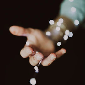 a person's hand holding a string of lights