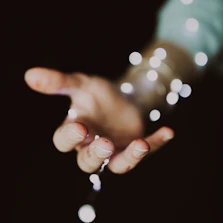 a person's hand holding a string of lights