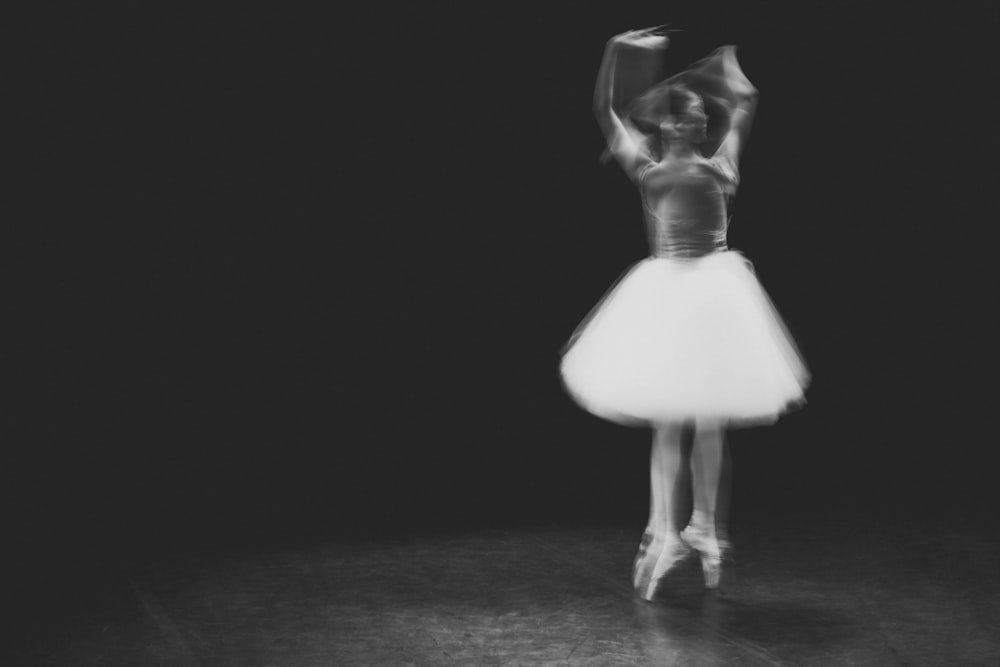 a black and white photo of a woman in a tutu