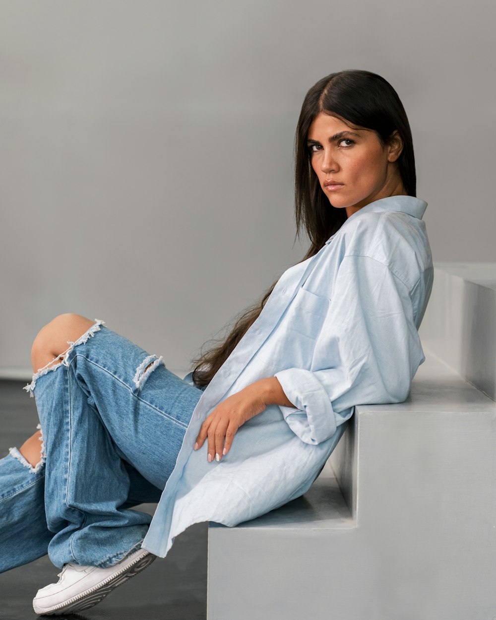 a woman sitting on a step with her legs crossed