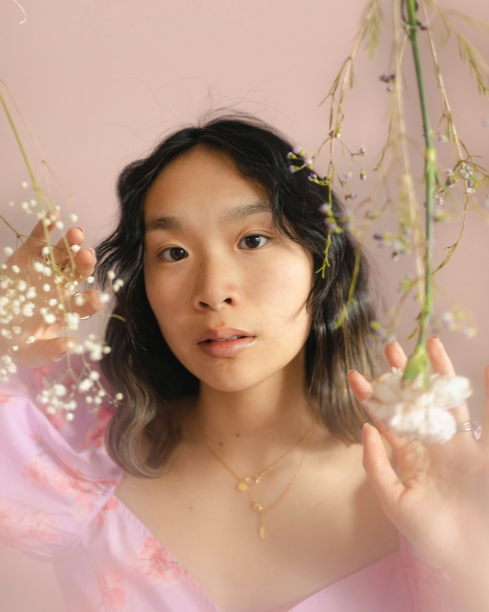 a woman in a pink dress holding flowers