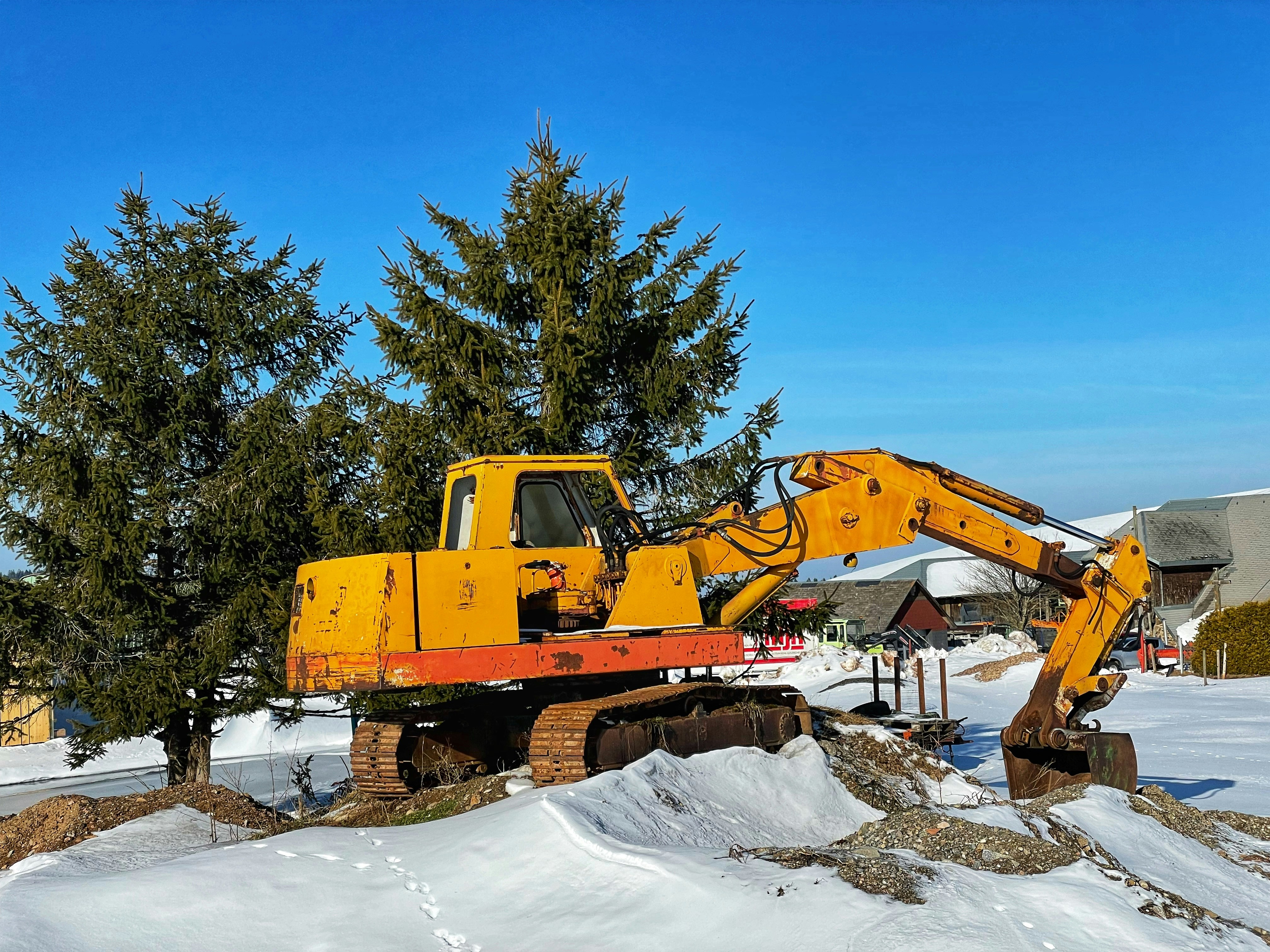 a large yellow machine is in the middle of a pile of snow