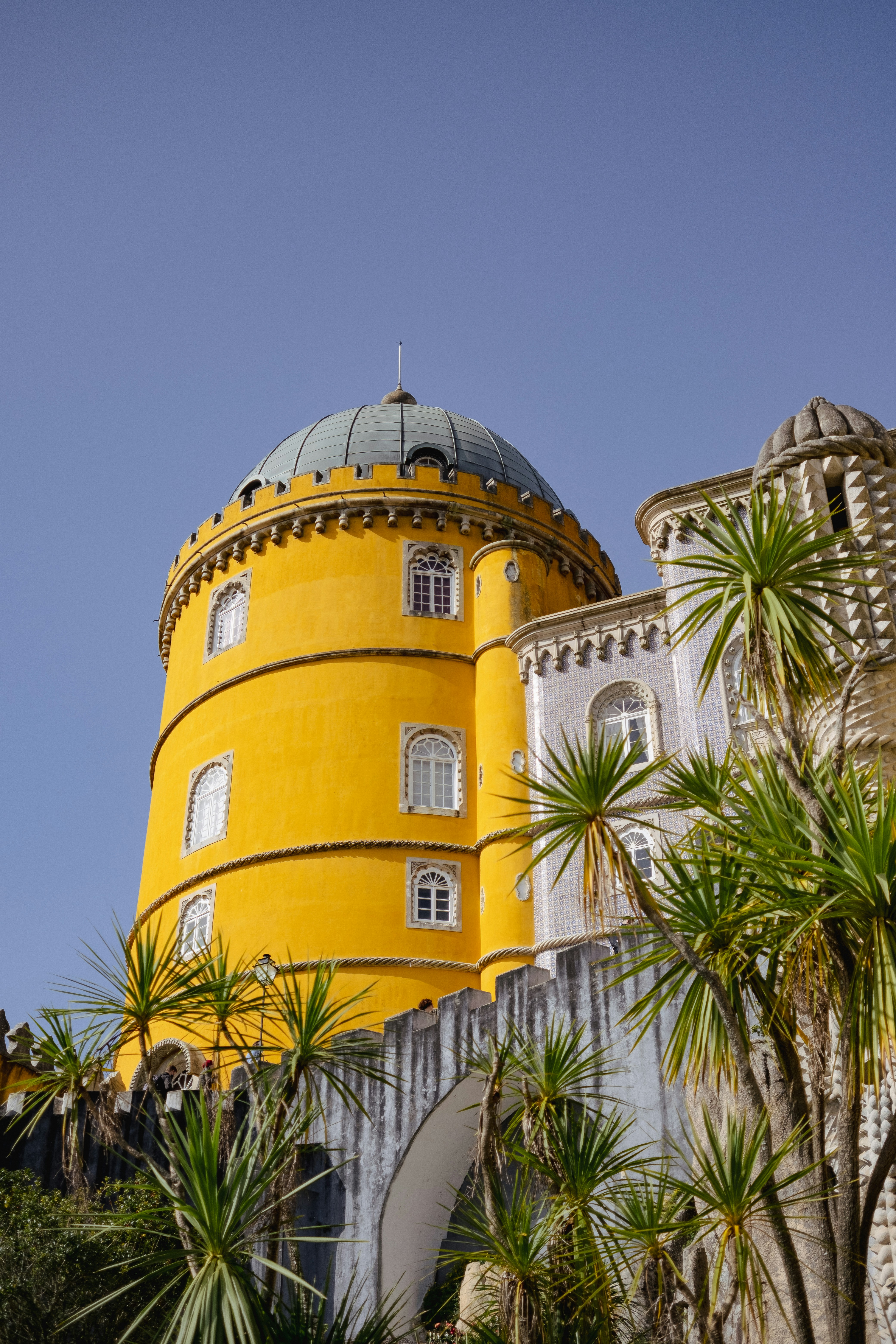 a large yellow building sitting on top of a lush green hillside