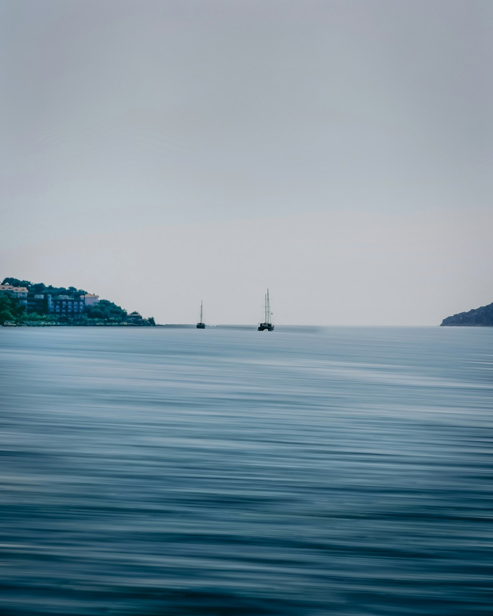 a body of water with two boats in the distance