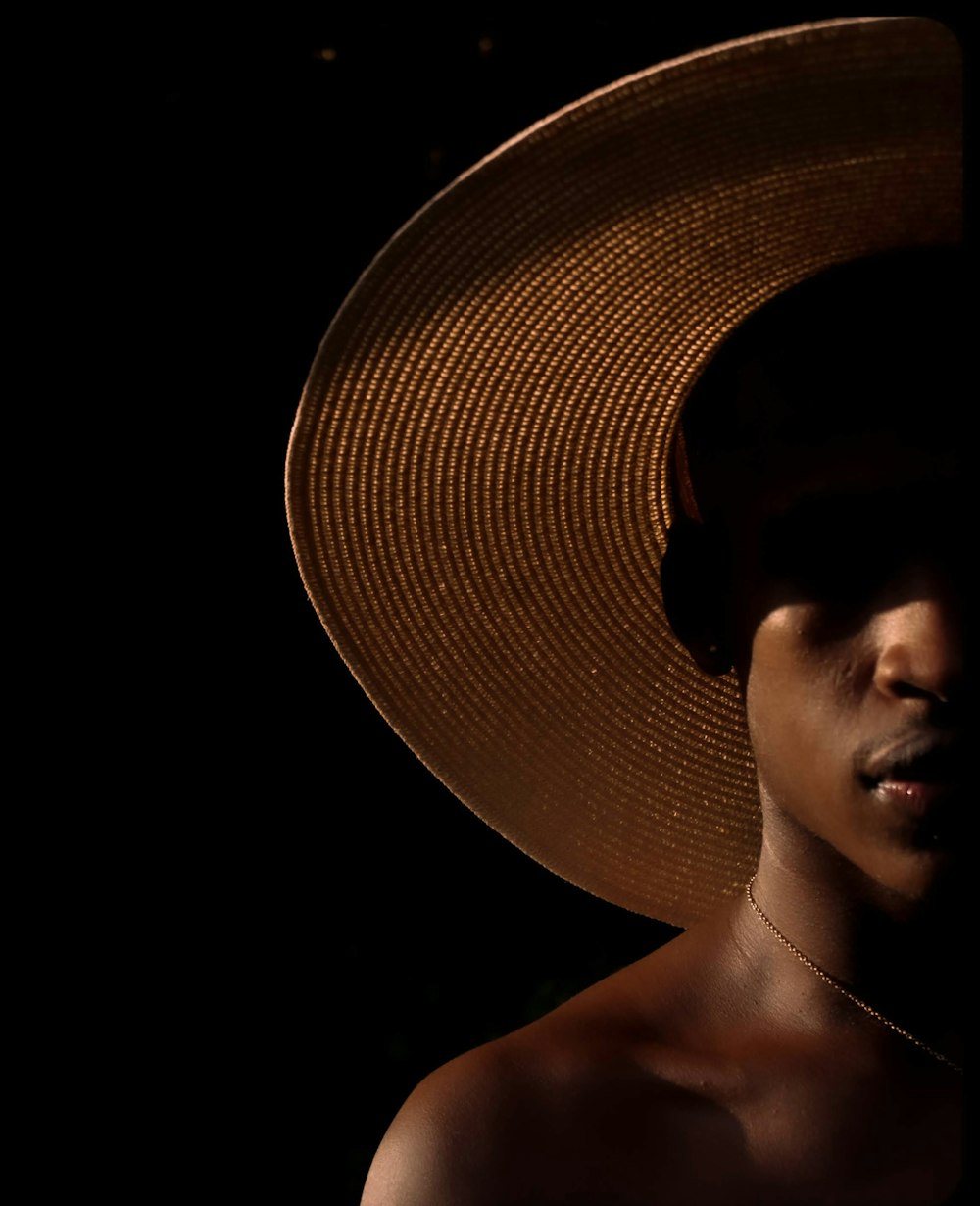 a man wearing a large hat in the dark