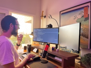 Photo of Gabriel Campos coding in a cozy home office with multiple monitors