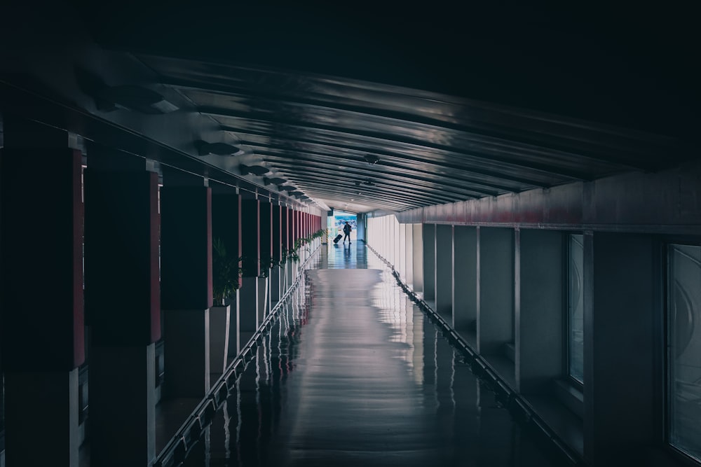 a long hallway in a building with a person walking down it