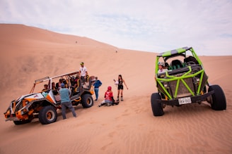 a group of people standing around a vehicle in the desert