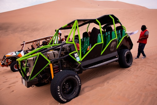a person standing next to a vehicle in the desert