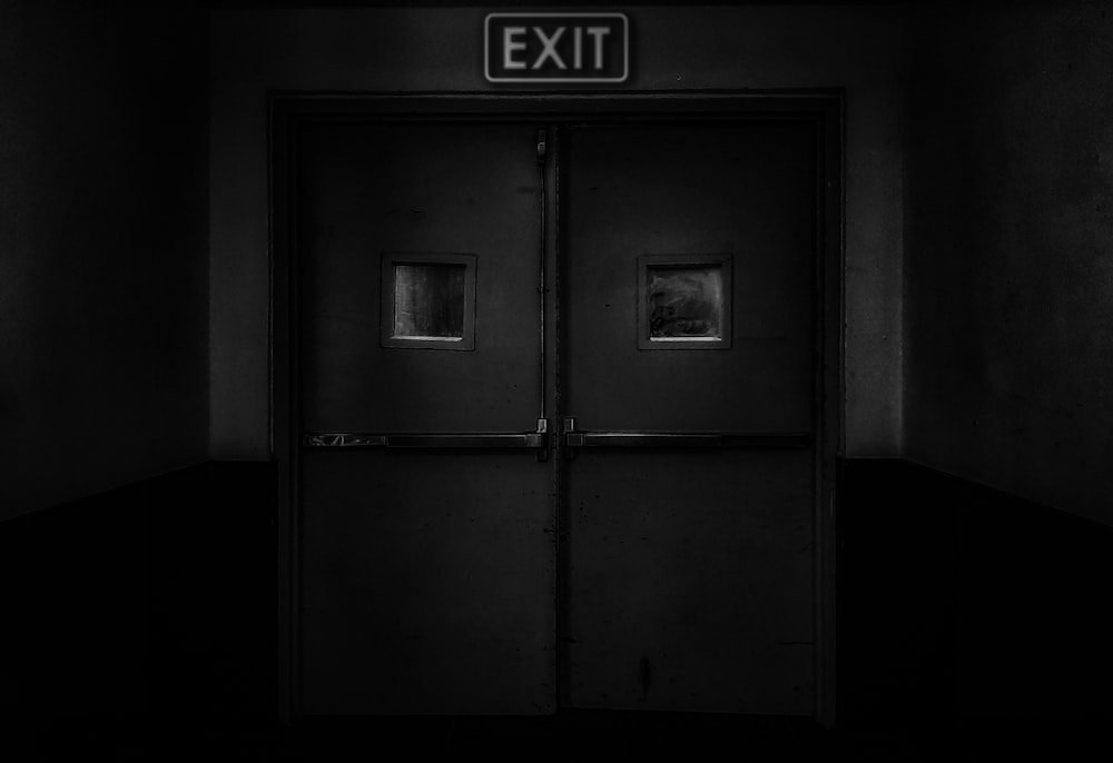 a black and white photo of an exit sign